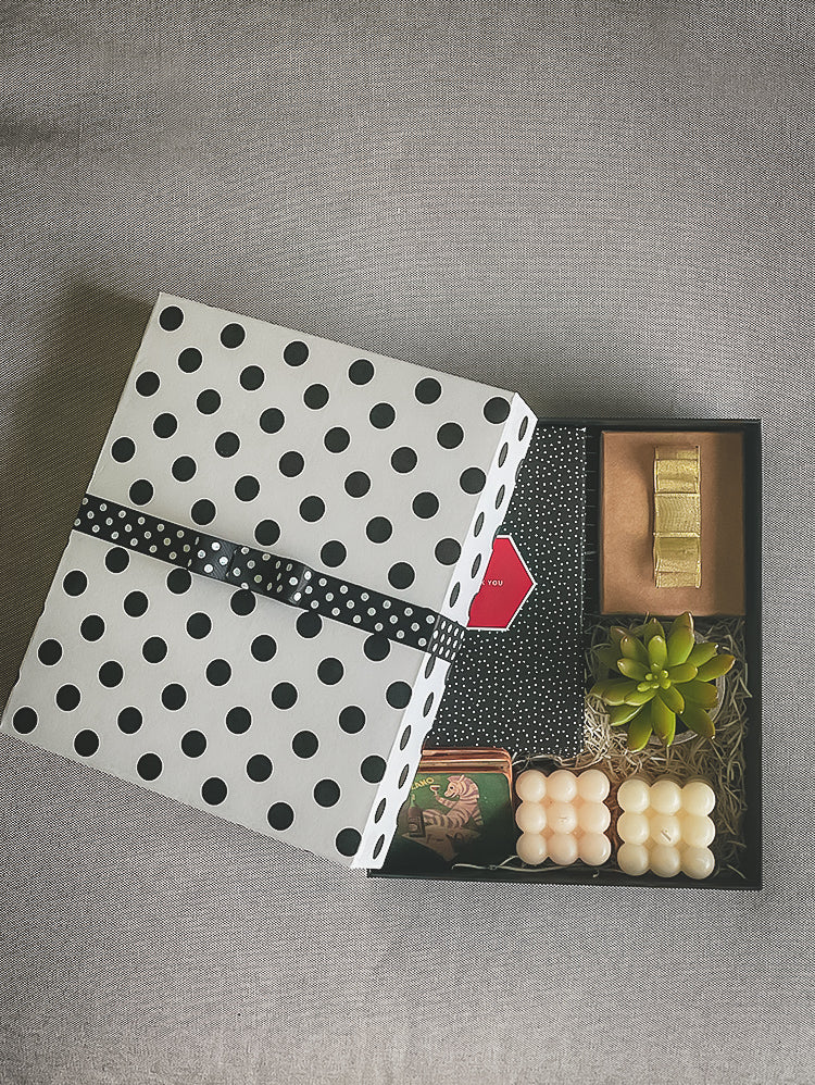 Black and white polka dot rigid gift box with crossed ribbon tie