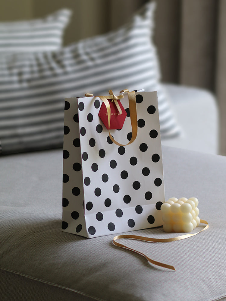 Polka dot gift bag with gold ribbon and tag